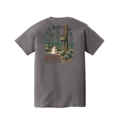 Pine Woods Watch Lowcountry Backroads youth T-shirt graphic featuring a camouflaged tree stand, pine forest, palmettos and woodland trail